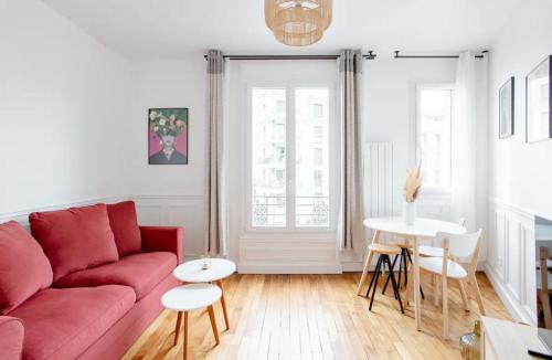 un salon avec un canapé rouge et une table dans l'établissement Charmant Appartement Cosy à Suresnes, à Suresnes