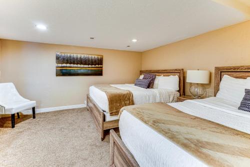 a hotel room with two beds and a chair at Sprawling Utah Mansion with Private Hot Tub and Sauna in Draper