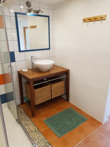 une salle de bain avec un lavabo et un miroir dans l'établissement Maison en pierre de hameau, à Aizac