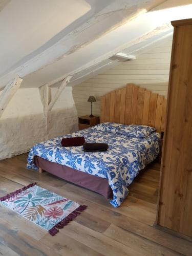 une chambre avec un lit dans un grenier dans l'établissement Maison en pierre de hameau, à Aizac