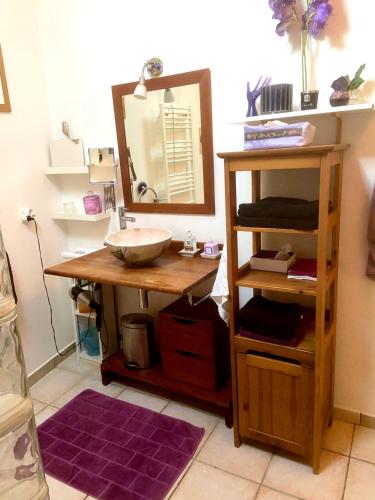 La salle de bains est pourvue d'un lavabo et d'un miroir sur une table. dans l'établissement Maison de charme d'Ile de France, à Chaumontel