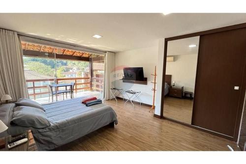 a bedroom with a bed and a view of a balcony at Casa Indaiá in Petrópolis