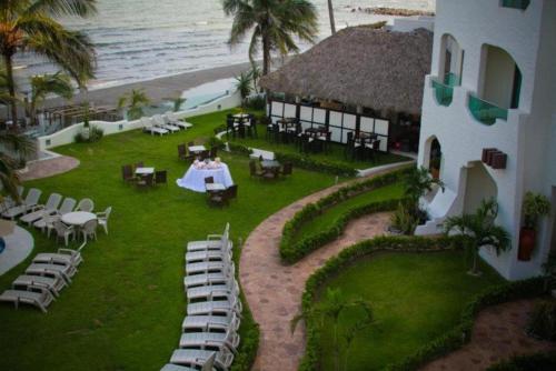 a resort with a table and chairs and the ocean at Playa Caracol Hotel & Spa in Veracruz