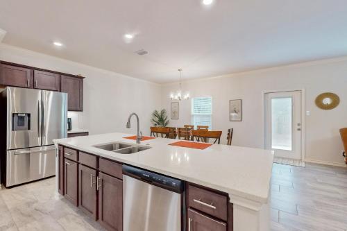 a kitchen with a stainless steel refrigerator and a table at Gulf Coast Haven in Aransas Pass