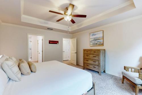 a bedroom with a white bed and a ceiling fan at Gulf Coast Haven in Aransas Pass