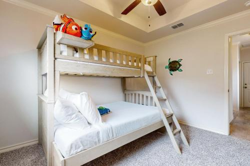 a bunk bed in a room with a ladder at Gulf Coast Haven in Aransas Pass