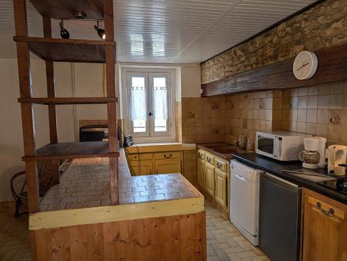 une cuisine avec une cuisinière et un micro-ondes dans l'établissement La bougie perlée 1, à Saint-Crépin-et-Carlucet