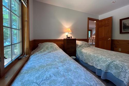 a bedroom with two beds and a window at Moose & Red Fox Retreat in Denmark
