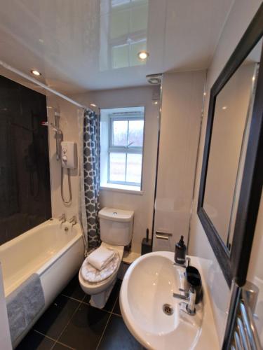 a bathroom with a sink and a toilet and a tub at Great prices on stays-Jubilee in Low Team