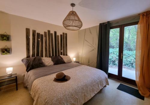 une chambre avec un lit avec un chapeau dessus dans l'établissement Casa Sereno - Appartement avec piscine chauffée et couverte, à Saint-Laurent-du-Pape