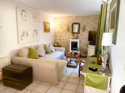 a living room with a couch and a table at Maison de charme d'Ile de France in Chaumontel