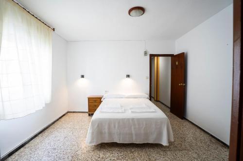 a white bedroom with a bed and a window at Hostal Residencia Pasaje in Novelda