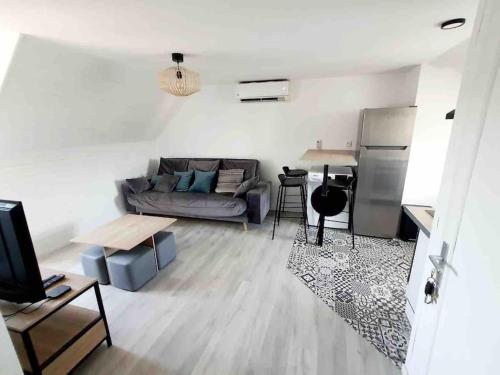 a living room with a couch and a table at jolis logements brivistes 4 in Brive-la-Gaillarde