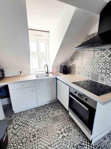 a white kitchen with a sink and a stove at jolis logements brivistes 4 in Brive-la-Gaillarde