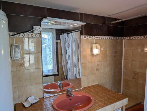 a bathroom with two red sinks and a mirror at La bougie perlée 1 in Saint-Crépin-et-Carlucet
