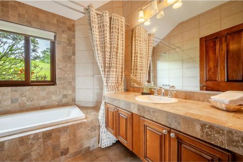 a bathroom with a tub and a sink and a tub and a window at Casa Shamrock Duplex 2 in Unión