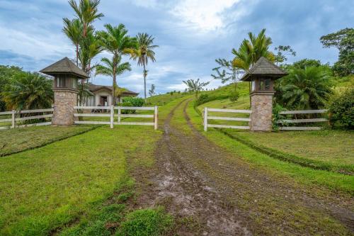 a white fence and two gates on a dirt road at Casa Shamrock Duplex 2 in Unión