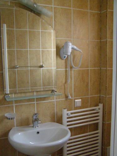 a bathroom with a sink and a phone on the wall at Pension Harmonia in Miercurea-Ciuc