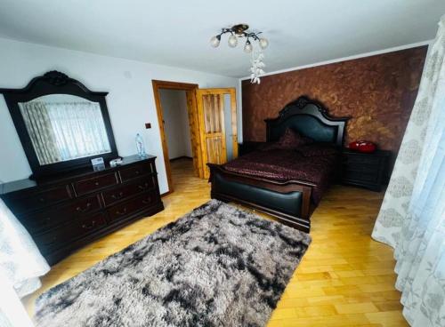 a bedroom with a large bed and a rug at Transilvania Guesthouse in Miercurea Sibiului