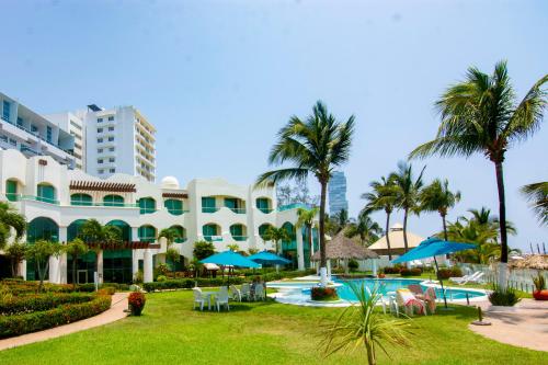 a resort with a pool and palm trees at Playa Caracol Hotel & Spa in Veracruz