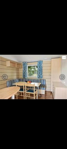 une salle à manger avec une table et des chaises bleues dans l'établissement Mobil-home camping la Dune Blanche, à Camiers
