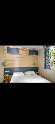 une chambre avec deux lits blancs et une fenêtre dans l'établissement Mobil-home camping la Dune Blanche, à Camiers