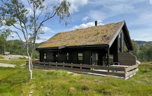 a log cabin with a grass roof on a field at Lovely Home In Vikeså With Kitchen in Vikeså