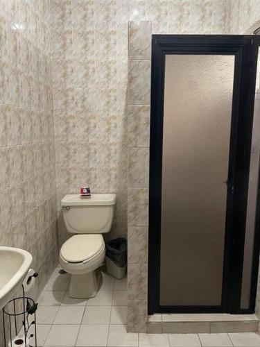 a bathroom with a toilet and a sink at La Casa Rosa Monterrey in Monterrey