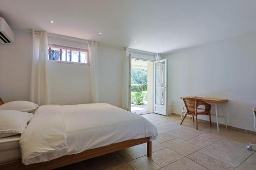 une chambre avec un lit, une table et un bureau dans l'établissement VILLA SéRéNITé, à Grimaud