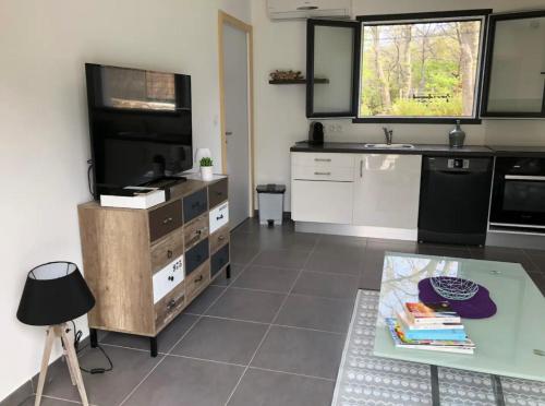 a kitchen with a table and a tv and a counter at Villa De Charme T3 Saint Florent in Barbaggio