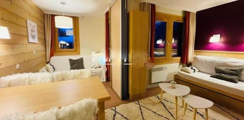 un salon avec un canapé et une table dans l'établissement APPARTEMENT charme SPA & PARKING COUVERT Au pied des pistes Plagne 1800, à La Plagne Tarentaise