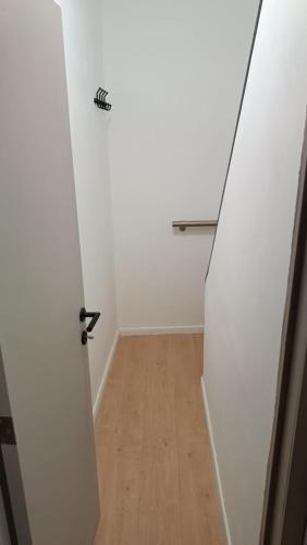 an empty hallway with a door and a wooden floor at Ubuntu House - Charleroi in Charleroi
