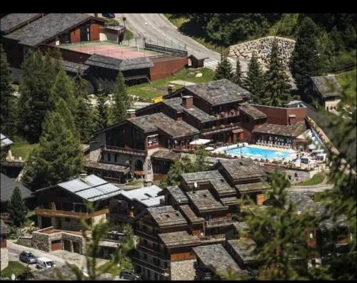 une vue aérienne d'une grande maison avec piscine dans l'établissement APPARTEMENT charme SPA & PARKING COUVERT Au pied des pistes Plagne 1800, à La Plagne Tarentaise