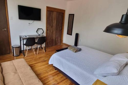 a bedroom with a bed and a table and a desk at Viñedito del coyote, Coyoacán in Mexico City