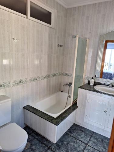 a bathroom with a tub and a toilet and a sink at Piso Beiramar O Grove in O Grove