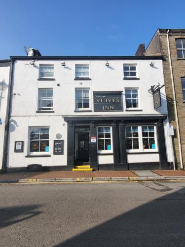 a white building with a sign that reads snakes inn at St Ives in Neath