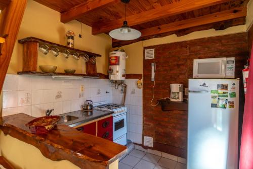 una cocina con frigorífico y fregadero en Cabañas Rayun, en Villa Ventana