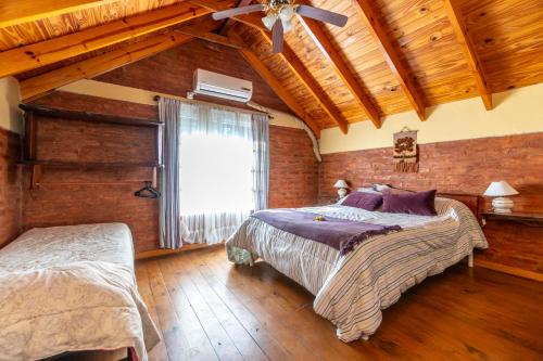 a bedroom with two beds and a ceiling fan at Cabañas Rayun in Villa Ventana