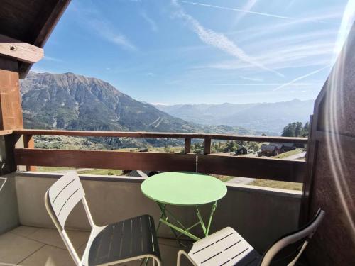 une table et des chaises sur un balcon avec vue sur les montagnes dans l'établissement Résidence Gardette - Adorable t2 pour 8 personnes au Réallon B42 MAE-8471, à Réallon