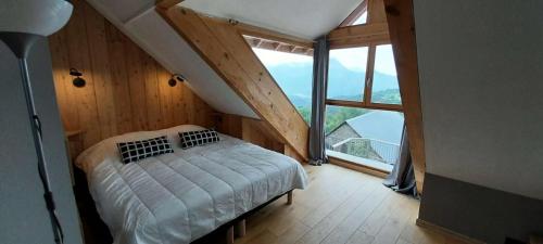 une chambre avec un lit et une grande fenêtre dans l'établissement Résidence Means - Jolie petite maison de 3 couchages en village MEANS VILLAGE MAE-8421, à Réallon