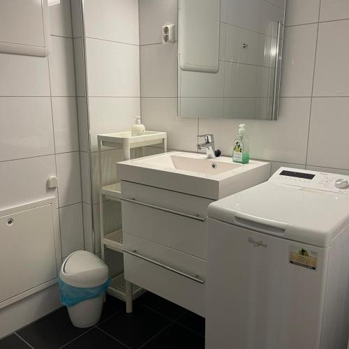 a white bathroom with a sink and a mirror at Engen 6 in Bergen