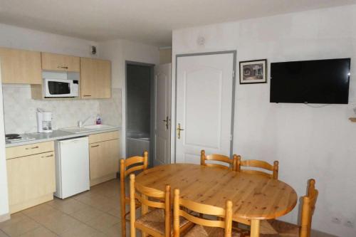 une cuisine avec une table et des chaises en bois ainsi qu'une cuisine avec un évier dans l'établissement Résidence Gardette - Joli T2 6 couchages à Réallon B13 MAE-8521, à Réallon