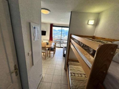 une chambre avec des lits superposés et une salle à manger avec une table dans l'établissement Résidence Gardette - Très joli appartement accueillant 4 personnes à Réallon B12 MAE-8531, à Réallon