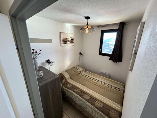une petite chambre avec un lit et une fenêtre dans l'établissement Résidence Gardette - Très joli appartement accueillant 4 personnes à Réallon B12 MAE-8531, à Réallon