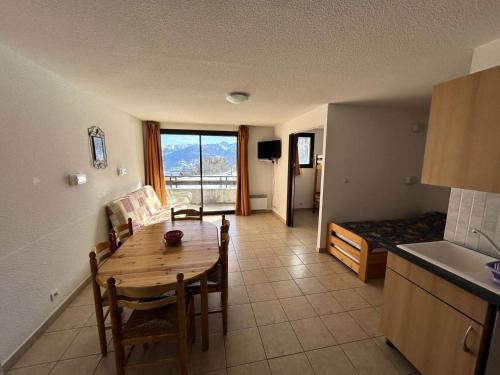 une cuisine et un salon avec une table et un canapé dans l'établissement Résidence Gardette - Ravissant T2 accueillant 6 personnes à Réallon A2 MAE-8571, à Réallon