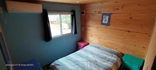 a small bedroom with a bed and a window at jazmin apart iguazu in Puerto Iguazú