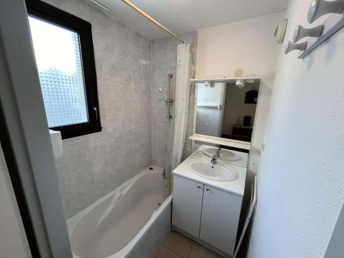 une salle de bain avec un lavabo et une baignoire et un lavabo dans l'établissement Résidence Gardette - Appartement 