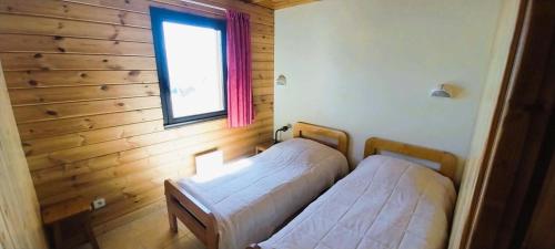 two beds in a room with a window at Résidence Joubelle - Appartement 6 personnes cosy dans chalet à Reallon JOUB1-6 MAE-8651 in Réallon