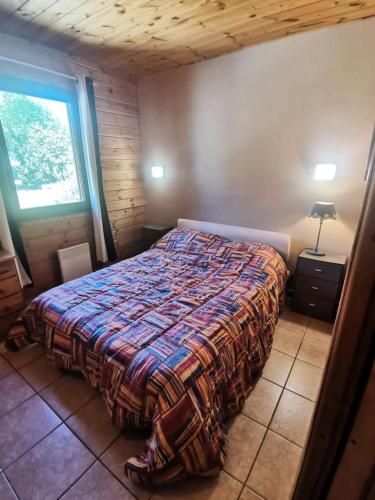 une chambre avec un lit avec une couverture dessus dans l'établissement Résidence Joubelle - Magnifique chalet de 6 couchages en duplex JOUB10-3 MAE-8641, à Réallon