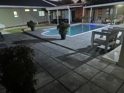 a patio with a bench and a swimming pool at Horizon Bed and Breakfast in Roodepoort